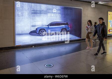 ---- Fußgänger vorbei an einer Werbung für NextEV Nio ES8 Smart Auto in Guangzhou City, der südchinesischen Provinz Guangdong, 23. Januar 2018. NI Stockfoto