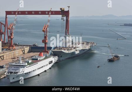 Chinesische Arbeiter Arbeit auf dem Deck von Chinas erstem im Inland gebaute Flugzeugträger, den Typ 001 A, auf der Werft von Dalian Schiffbauindustrie Stockfoto