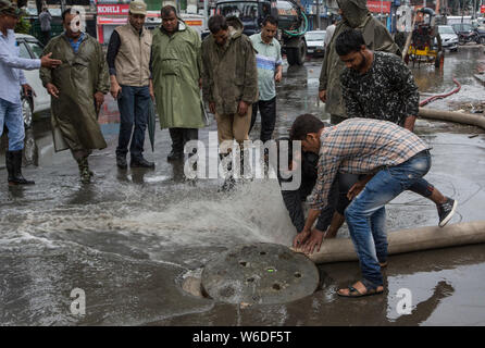 Srinagar, Indisch kontrollierten Teil Kaschmirs. 1 Aug, 2019. Arbeitnehmer Wasser von der Straße entfernen, während der Regen in Srinagar Stadt, der Sommer Hauptstadt von Indien kontrollierten Teil Kaschmirs, Aug 1, 2019. Credit: Javed Dar/Xinhua/Alamy leben Nachrichten Stockfoto