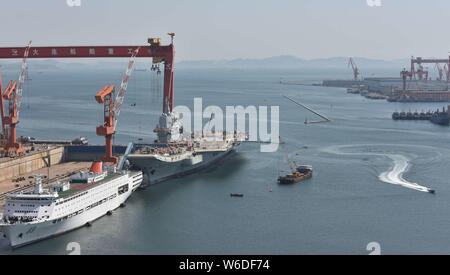 Chinesische Arbeiter Arbeit auf dem Deck von Chinas erstem im Inland gebaute Flugzeugträger, den Typ 001 A, auf der Werft von Dalian Schiffbauindustrie Stockfoto