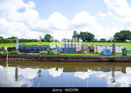 Reservierter Liegeplatz Platz für einen schmalen Boot genannt Moor Zeit mit eigenem Garten, und Messe, auf der Trent und Mersey Canal in Cheshire UK Stockfoto