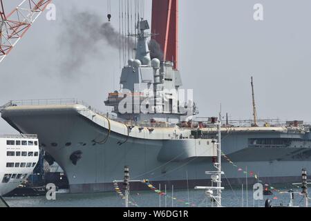 Chinesische Arbeiter Arbeit auf dem Deck von Chinas erstem im Inland gebaute Flugzeugträger, den Typ 001 A, auf der Werft von Dalian Schiffbauindustrie Stockfoto