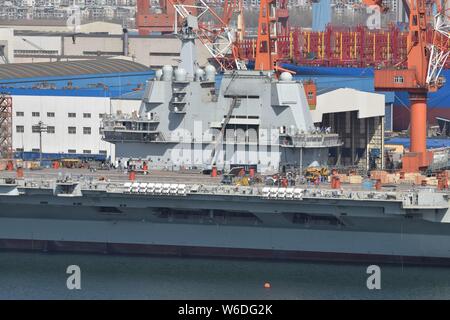 Chinesische Arbeiter Arbeit auf dem Deck von Chinas erstem im Inland gebaute Flugzeugträger, den Typ 001 A, auf der Werft von Dalian Schiffbauindustrie Stockfoto