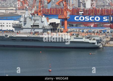 Chinesische Arbeiter Arbeit auf dem Deck von Chinas erstem im Inland gebaute Flugzeugträger, den Typ 001 A, auf der Werft von Dalian Schiffbauindustrie Stockfoto