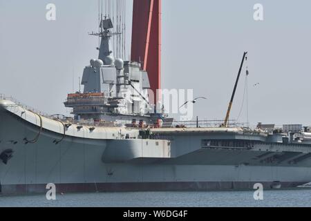 Chinesische Arbeiter Arbeit auf dem Deck von Chinas erstem im Inland gebaute Flugzeugträger, den Typ 001 A, auf der Werft von Dalian Schiffbauindustrie Stockfoto