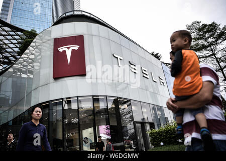 ---- Fußgänger vorbei an einer Händlerniederlassung Store von Tesla in Guangzhou City, der südchinesischen Provinz Guangdong, am 1. November 2017. Chinas Entscheidung zu Stockfoto