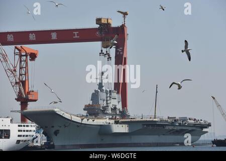 Chinesische Arbeiter Arbeit auf dem Deck von Chinas erstem im Inland gebaute Flugzeugträger, den Typ 001 A, auf der Werft von Dalian Schiffbauindustrie Stockfoto