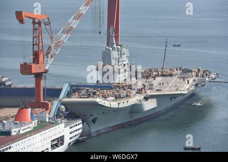 Chinesische Arbeiter Arbeit auf dem Deck von Chinas erstem im Inland gebaute Flugzeugträger, den Typ 001 A, auf der Werft von Dalian Schiffbauindustrie Stockfoto