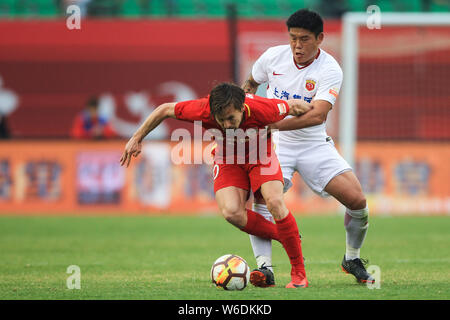 Cai Huikang, rechts, von Shanghai SIPG Herausforderungen dänischer Fußballspieler Lasse Vibe von Changchun Yatai in der 8. Runde während der 2018 Chinesischen Stockfoto