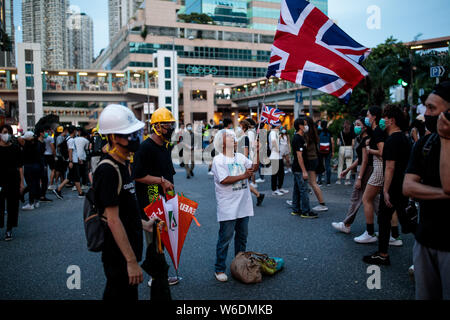 Eine Frau fliegt eine Union Jack Flagge bei Anti-Auslieferung bill Demonstrationen in Sheung Shui, Hong Kong am 13. Juli 2019. Pro-demokratischen Demonstranten weiter mit Demonstrationen, wie sie für den vollständigen Abzug der eine umstrittene Auslieferung Bill und der Verwaltungschefin von Hong Kong Executive Carrie Lam. Stockfoto