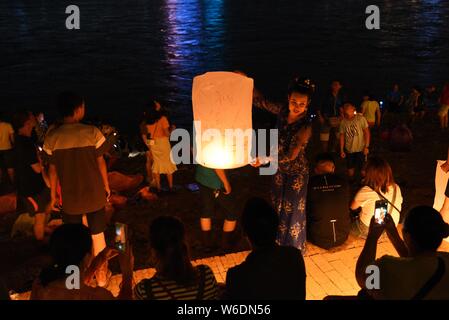 Menschen release Himmelslaternen, auch als Laternen Kongming bekannt, bei der Bank von lancang River der 1380Th neues Jahr des Dai ethnische Minderheit zu feiern. Stockfoto