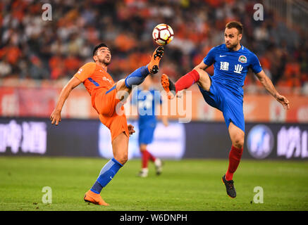 Italienische Fußballspieler Graziano Pelle, links, von Shandong Luneng Taishan Herausforderungen spanischer Fußballspieler Cala von Henan Jianye in der 8. Runde ma Stockfoto