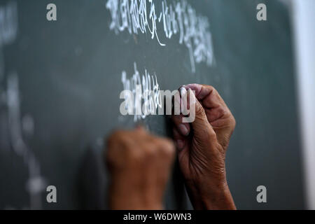 (190801) -- HEXIAN, August 1, 2019 (Xinhua) - Ihr lianping bereitet sich für die englische Lektion am nächsten Tag in der Klasse der 'Zuhause für Kinder' links hinter in Buchen Dorf Hexian County in der ostchinesischen Provinz Anhui, 30. Juli 2019. Ihr lianping, einen 92-jährigen pensionierten Lehrer in Buchen Dorf Hexian County, Einrichten der 'Home links hinter Kindern" im Jahr 2000, um sie zu unterrichten Englisch Unterricht für Sie kostenlos. Wie die meisten jungen Menschen Arbeit weit entfernt, Ältesten und Kinder hinter sind im Dorf links. Ohne Kind selbst, Ihr lebt mit seiner Frau in ein Bungalow gebaut vor 30 Jahren, wo er t bietet Stockfoto