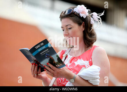 Eine racegoer liest das Rennen Karte während der Tag drei der Qatar Goodwood Festival in Goodwood Rennstrecke, Chichester. Stockfoto