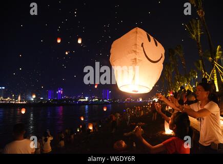 Menschen release Himmelslaternen, auch als Laternen Kongming bekannt, bei der Bank von lancang River der 1380Th neues Jahr des Dai ethnische Minderheit zu feiern. Stockfoto