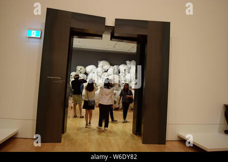 Besucher Ansicht 'Masse', ein Kunstwerk von 100 überlebensgroße Schädel durch australische Bildhauer Ron Mueck, auf Anzeige während der Ngv dreijährlichen Ausstellung ein Stockfoto
