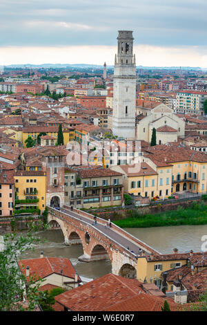 Blick über die Dächer von Verona, Italien, über den Fluss Etsch und die Steinerne Brücke (Ponte Pietro) mit dem Turm der Kathedrale dominiert. Stockfoto
