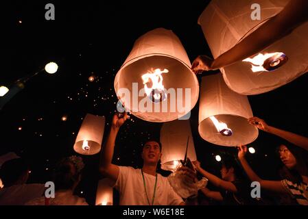 Menschen release Himmelslaternen, auch als Laternen Kongming bekannt, bei der Bank von lancang River der 1380Th neues Jahr des Dai ethnische Minderheit zu feiern. Stockfoto