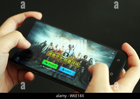 ---- Eine Chinesische mobile Game Player spielt's Tencent multiplayer Online Battle Royale's Spiel PlayerUnknown Schlachtfelder, auf sein Smartphone in Ji'nan Stockfoto