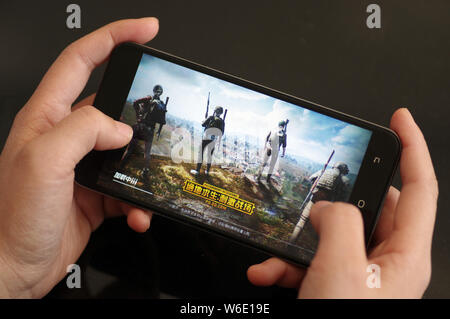 ---- Eine Chinesische mobile Game Player spielt's Tencent multiplayer Online Battle Royale's Spiel PlayerUnknown Schlachtfelder, auf sein Smartphone in Ji'nan Stockfoto