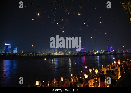Menschen release Himmelslaternen, auch als Laternen Kongming bekannt, bei der Bank von lancang River der 1380Th neues Jahr des Dai ethnische Minderheit zu feiern. Stockfoto