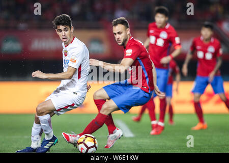 Brasilianische Fußballspieler Oscar, links, von Shanghai SIPG Herausforderungen spanischer Fußballspieler Cala von Henan Jianye in ihrem fünften Runde während der Stockfoto