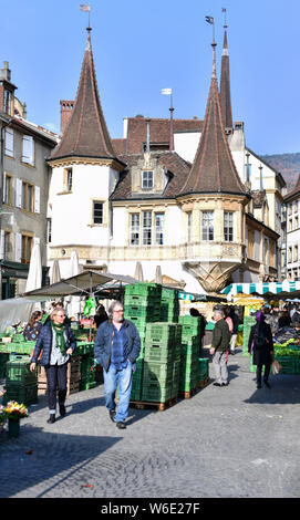 Schweiz: Neuenburg. Typische Appartementgebäude mit Passanten auf dem Markt der Place de Halles entfernt. Maison Des Halles im Hintergrund, ein Stockfoto