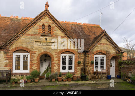 Die Exerzitien, eine Terrasse von historischen Armenhäuser stammt aus dem Jahr 1892, in einem Hinterhof an der High Street, Stony Stratford, UK eingestellt Stockfoto