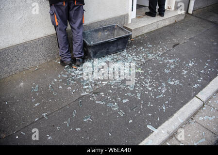 01. August 2019, Bayern, Röslau: Splitter eines zerbrochenen Glasscheibe liegen vor einer Bank Branche, in der ein Geldautomat bis in den frühen Morgen durchgebrannt war. Unbekannte einen Geldautomaten gesprengt in einer Bank in Oberfranken und floh dann von der Polizei. Die Suche ist noch im Gange. Foto: Nicolas Armer/dpa Stockfoto
