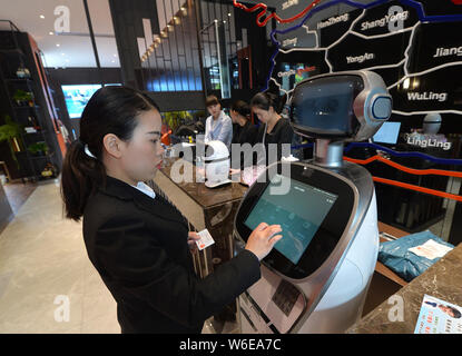 Ein chinesischer Mitarbeiter betreibt eine intelligente Roboter zu einem High tech Hotel in Chengdu City, im Südwesten Chinas Provinz Sichuan, 21. März 2018. Roboter ser Stockfoto