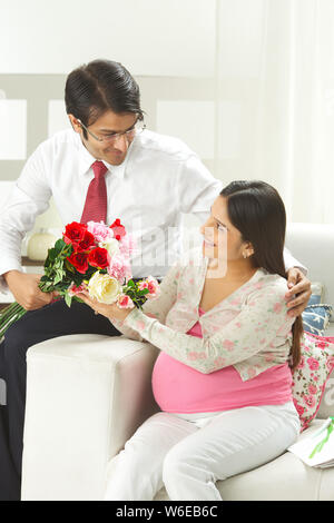 Geschäftsmann gibt Blumenstrauß zu seiner Frau Stockfoto