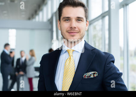 Jungen und selbstbewussten Geschäftsmann. Hübscher junger Mann in formale lächelnd an Kamera Stockfoto
