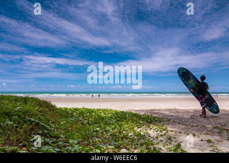 RAYONG, THAILAND - 16 Juli, 2019: Der Mensch holded Surfbrett, beim Gehen in das Meer zum Surfen. Stockfoto
