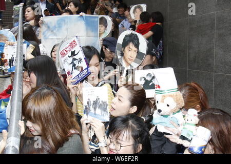 Chinesische Fans halten Poster japanische Schauspieler, Sänger, Fernsehen, Radio Persönlichkeit Shingo Katori, Center, das jüngste Mitglied der SMAP, an Stockfoto