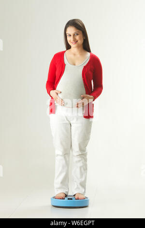 Schwangere Frau mit einem Gewicht von selbst Stockfoto