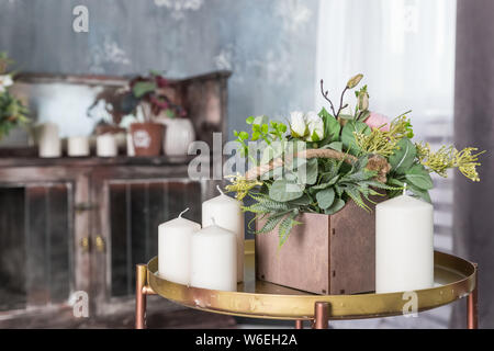 Organische duftende Soja Kerze auf einem kleinen Tisch. Loft Interieur, Minimalismus Konzept. Home dekorative Element auf Tabelle mit Holzbox mit Stockfoto