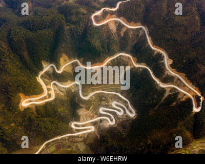 Luftaufnahme von einer gewundenen Autobahn rund um einen Berg in Congjiang County, qiandongnan Miao und Dong Autonomen Präfektur, Südwesten Chinas Guizhou pro Stockfoto