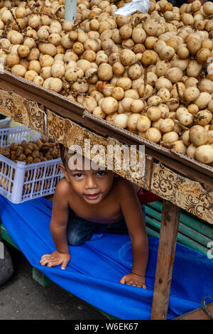 Ein kleiner Junge versteckt sich unter einer Kartoffel ausgeht, CO2-Markt, Cebu City, Cebu, Philippinen Stockfoto