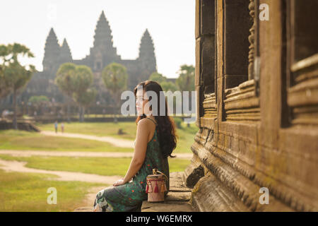 Candid Portrait von brunette Asiatischen alleinreisende Frauen in Siem Reap, Kambodscha. Es gibt einen berühmten Angkor Wat Tempel im Hintergrund. Stockfoto