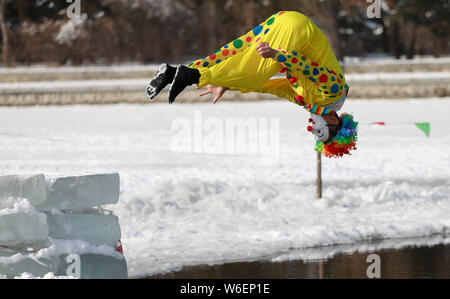 Eine chinesische Winter schwimmen Enthusiasten in der Clown Kostüm führt lustig Tauchen in Beiling Park in Shenyang City, im Nordosten der chinesischen Provinz Liaoning p Stockfoto