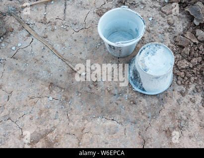Twin Kunststoffeimer mit dem Zement Fleck auf dem Boden der Baustelle. (space Kopieren) Stockfoto