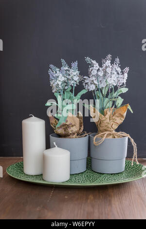 Bio Soja Kerze auf grauem Beton Zement Wand Hintergrund. Loft Interieur, Minimalismus Konzept. Schäbigen alten Inneneinrichtung für Bauernhaus. Lavendel Stockfoto