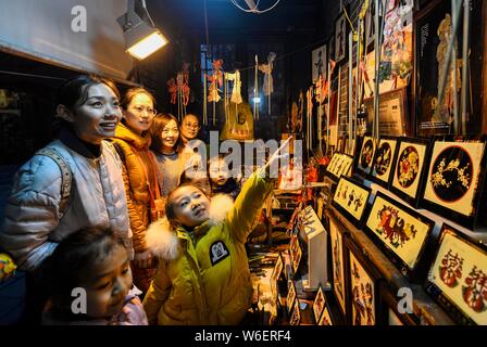 Besucher Blick auf die schattenfiguren durch 60-jährige Chinese Folk Künstler Chen Shouke verwendet Schattenspiel oder schattenpuppenspiel auf Anzeige in T durchführen Stockfoto