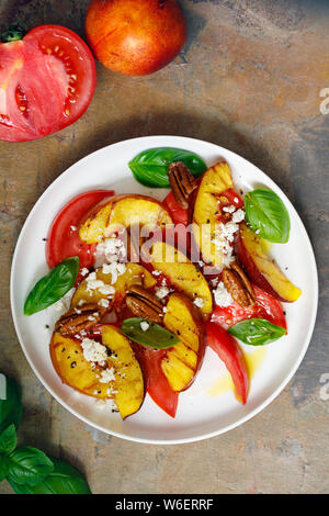 Gegrillter Pfirsich und Erbe Tomatensalat Stockfoto