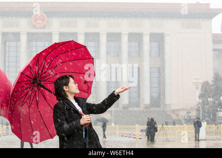 Ein Journalist spielt mit Schnee vor der Großen Halle des Volkes in Peking, China, 17. März 2018. Stockfoto