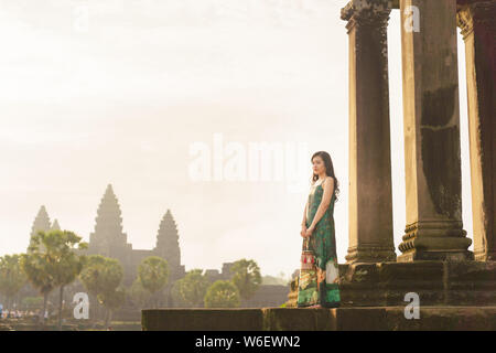 Candid Portrait von brunette Asiatischen alleinreisende Frauen in Siem Reap, Kambodscha. Es gibt einen berühmten Angkor Wat Tempel im Hintergrund. Stockfoto