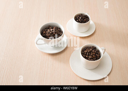 Voll Kaffeebohnen Tassen auf dem Holz Hintergrund Stockfoto