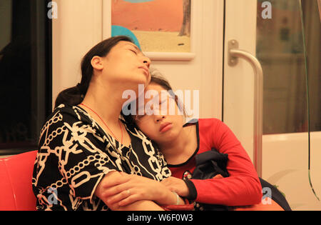 ------ Einer chinesischen Mutter und Tochter einschlafen, da Sie eine U-Bahn in Nanjing city, der ostchinesischen Provinz Jiangsu, 25. Mai 2014. Aroun Stockfoto