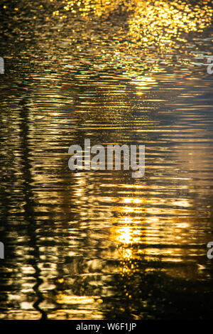 Zusammenfassung von früh morgens die reflektierenden Sonnenstrahlen das Wasser in einem Teich in Georgien Stockfoto