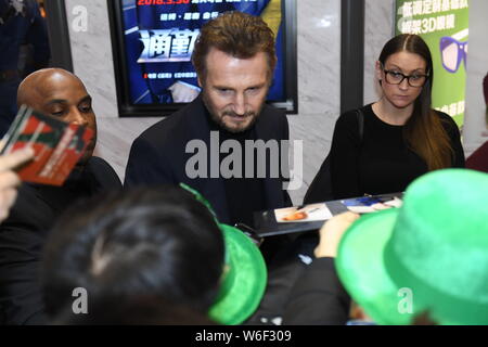 Hollywood Schauspieler Liam Neeson Autogramme für die Fans, als er auf dem roten Teppich zur Premiere seines neuen Films "Der Grenzgänger" in Peking, China ankommt Stockfoto